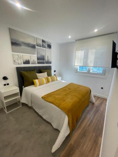 une chambre avec un grand lit et deux fenêtres dans l'établissement Villa Valentina Cíes, à Vilagarcía de Arousa