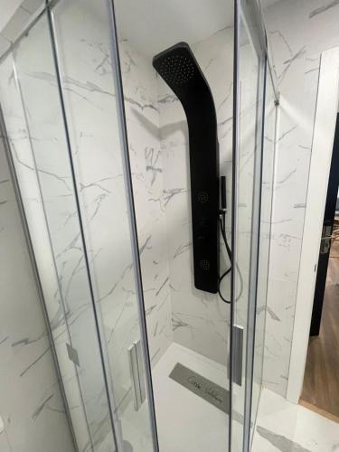 une douche avec une porte en verre à côté d'un mur dans l'établissement Villa Valentina Cíes, à Vilagarcía de Arousa