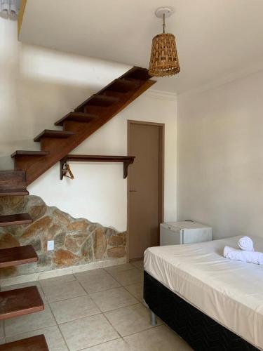 a bedroom with a bed and a stair case at Pousada Prime Center in Pipa