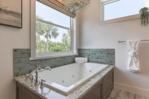 Un baño con bañera y ventana. en Deja Blue, en Sanibel