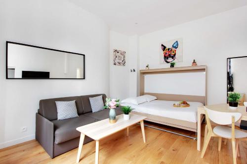 un salon avec un canapé et une table dans l'établissement Charmant Studio au coeur de la vie parisienne, à Paris