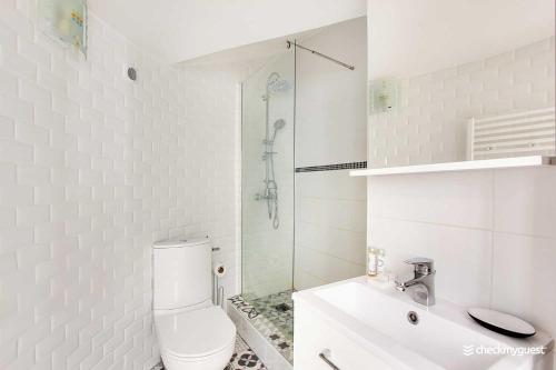 une salle de bain blanche avec toilettes et douche dans l'établissement Charmant Studio au coeur de la vie parisienne, à Paris