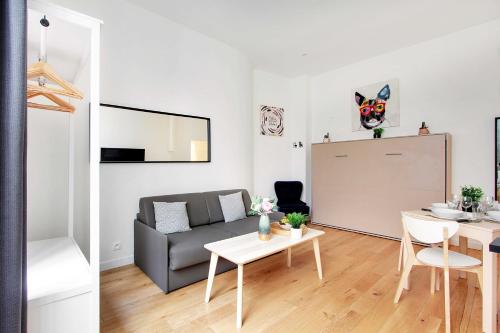 un salon avec un canapé et une table dans l'établissement Charmant Studio au coeur de la vie parisienne, à Paris