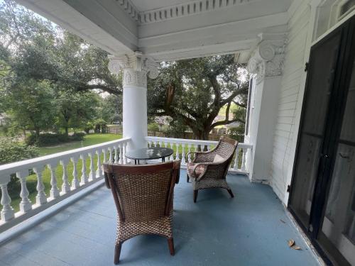 two chairs and a table on a porch at Historic Michabelle Inn in Hammond