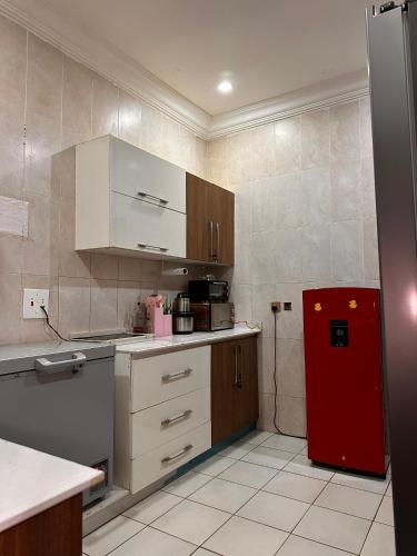 a kitchen with a red refrigerator and white cabinets at Savannah Homes in Abuja