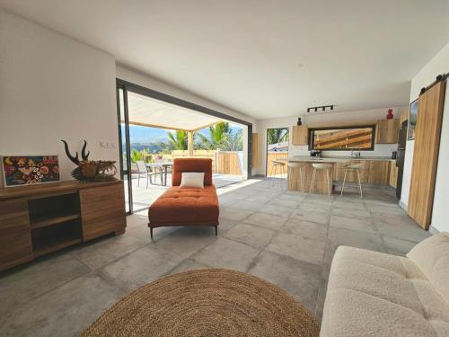 a living room with a couch and a kitchen at Villa Eclats Panoramiques in Saint-Pierre