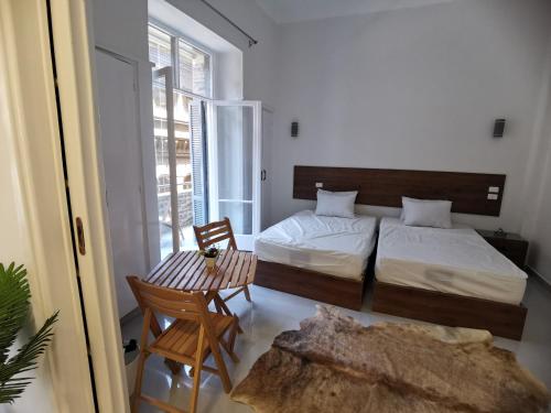 a bedroom with two beds and a table and chairs at family suites cairo downtown in Cairo
