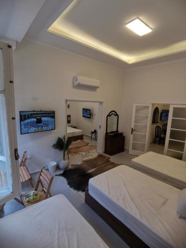 a bedroom with two beds and a tv on the wall at family suites cairo downtown in Cairo