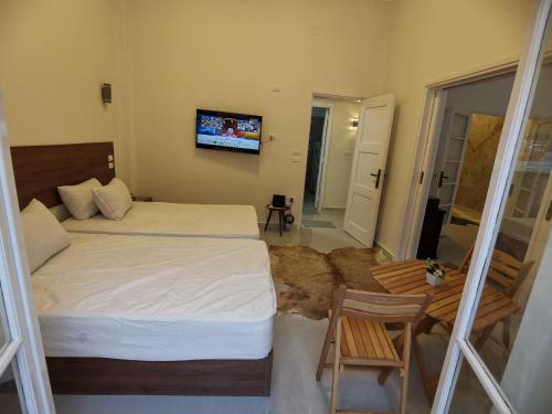 a bedroom with two beds and a tv on the wall at family suites cairo downtown in Cairo
