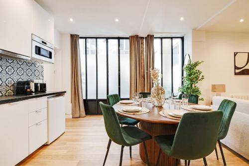 une cuisine et une salle à manger avec une table et des chaises dans l'établissement Elegant Appartement neuf 2 BDR 6P - Republique, à Paris
