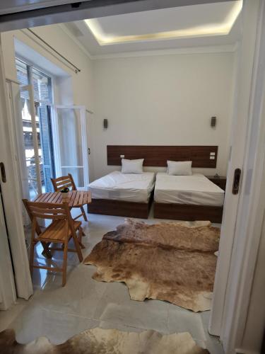 a bedroom with two beds and a chair and a table at family suites cairo downtown in Cairo