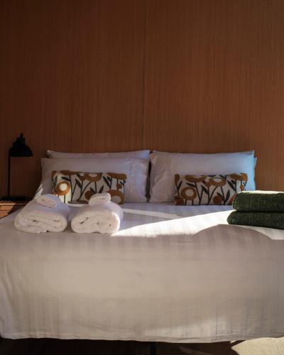 a bed with two towels on top of it at Forest Farm Tiny House by Tiny Away in Tauranga
