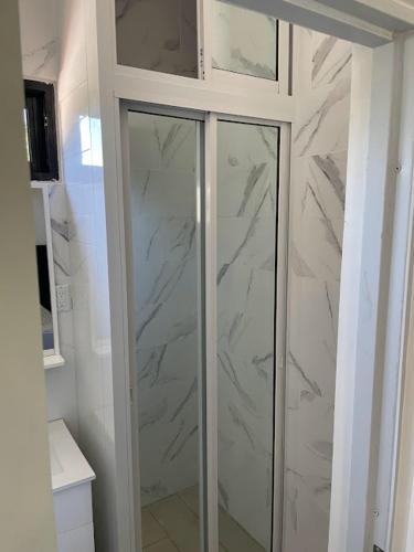 a bathroom with a glass shower with marble walls at LEVEL suites #8 in Sosúa