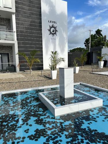a swimming pool with a fountain in front of a building at LEVEL suites #8 in Sosúa