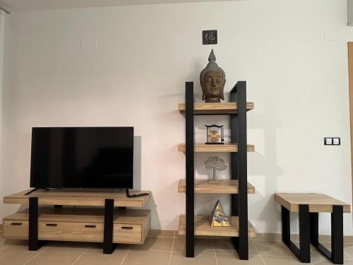 a flat screen tv sitting on a stand next to a wall at Real Dreams in Sant Jaume d'Enveja