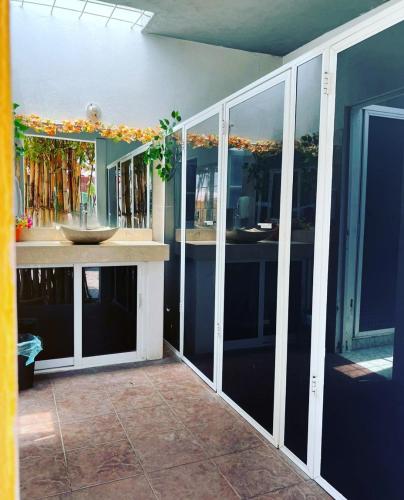a room with glass doors and a counter with a sink at Residencia Mirenick in Cuautlixco