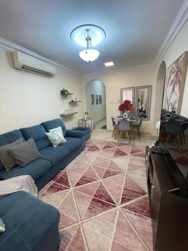 a living room with a blue couch and a table at Beautiful Flat By The Beach Salalah in Salalah