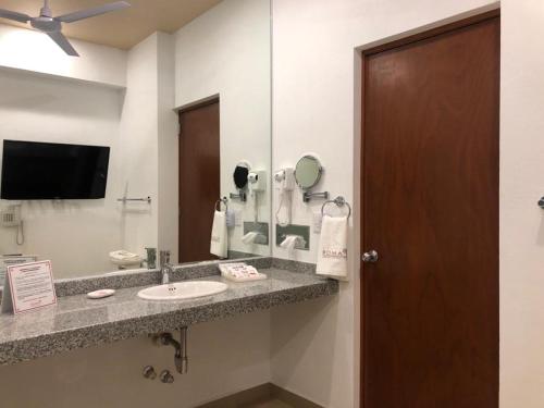 a bathroom with a sink and a mirror at Hotel Roma in Cosamaloapan de Carpio