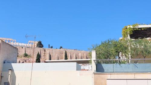 une vue d'un bâtiment avec une colline en arrière-plan dans l'établissement Elegant apartment in Acropolis, à Athènes