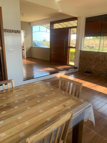 a dining room with a wooden table and chairs at A Casa Cuesta Pousada in Pardinho