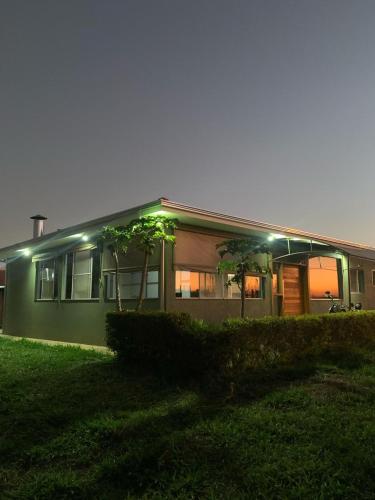 a house at night with the lights on at A Casa Cuesta Pousada in Pardinho