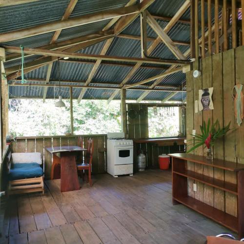 a large room with a table and a stove at Pavones Rustic Jungle Cabin in Pavones