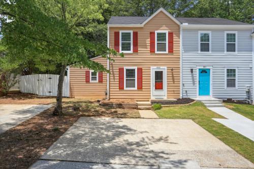 a house with a blue door and a tree at Warm 2-Story Townhome in Smyrna