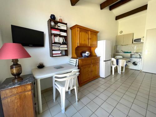 une cuisine avec une table et un bureau avec des chaises dans l'établissement Charmant studio à 150 m du club de plongée, terrasse et parking à Banyuls-sur-Mer - FR-1-309-87, à Banyuls-sur-Mer