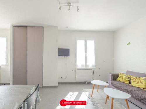 un salon avec un canapé et une table dans l'établissement Appartement T2 à 100m de l'Océan, tout confort avec parking privatif, pour 4 personnes - FR-1-535-58, à Angoulins-sur-Mer