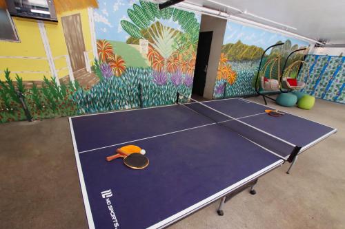 a ping pong table in a room with a mural at Waikiki Beachside Hostel in Honolulu