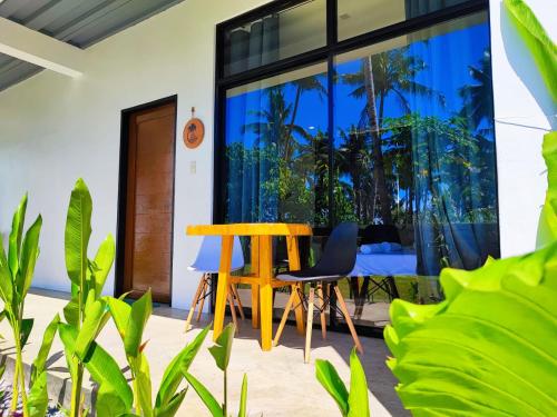 a patio with a table and chairs and plants at Casa Basa Siargao in General Luna