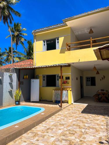 a house with a swimming pool in front of a house at Descanso Milagres in São Miguel dos Milagres