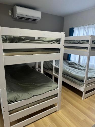 a room with three bunk beds in a room at 五所川原市街好立地 GreatLocation in Goshogawara