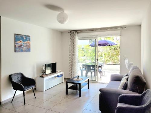 un salon avec un canapé et une télévision dans l'établissement Canet-en-Roussillon: T3 moderne, RDC, 4 pers, piscine, garage, proche mer - FR-1-794-156, à Canet