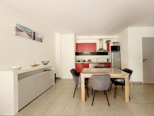 une cuisine et une salle à manger avec une table et des chaises dans l'établissement Canet-en-Roussillon: T3 moderne, RDC, 4 pers, piscine, garage, proche mer - FR-1-794-156, à Canet