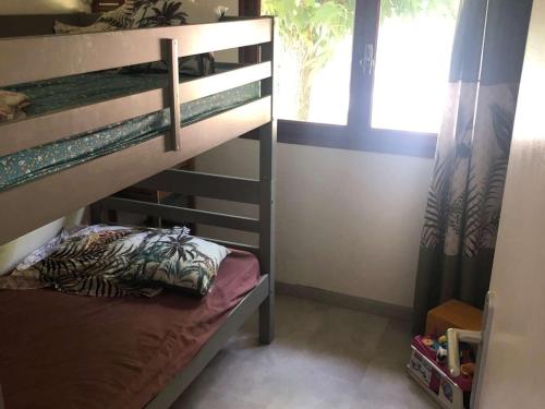 une chambre avec un lit superposé et une fenêtre dans l'établissement Maison Bungalow Climatisée avec Jardin Arboré, 3 Chambres, Wifi - Proche Plage et Commerces - FR-1-701-84, à Valras-Plage