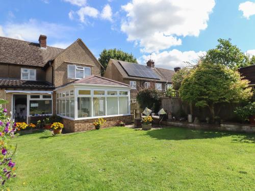 a house with a conservatory in a yard at Molly's Bit in Chipping Norton