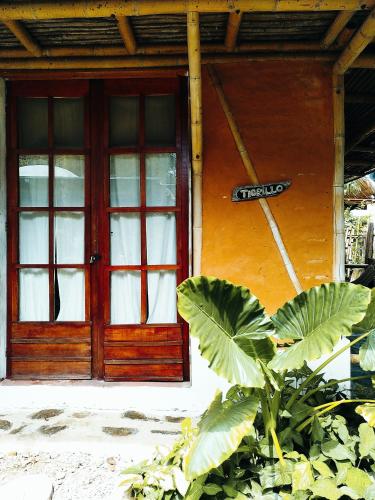 a door of a house with a sign in front at KUA Cabañas in Palomino