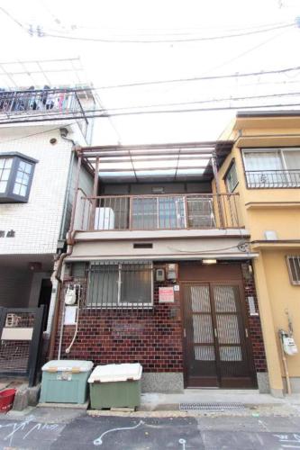 a brick house with two trash cans in front of it at Sunrise House 桃谷 in Osaka