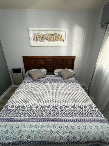 a bedroom with a bed with a blue and white comforter at Sierras in La Falda