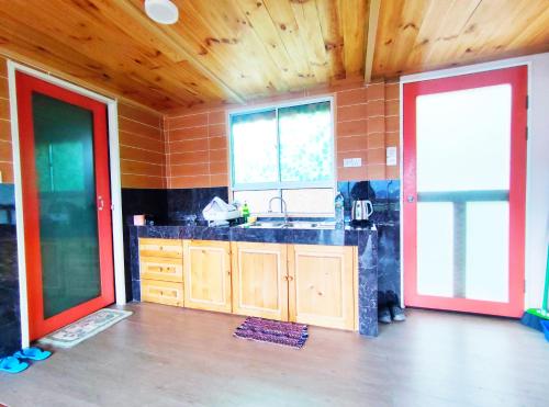 a kitchen with a sink and two windows in a room at Nulu View Cabin in Kundasang