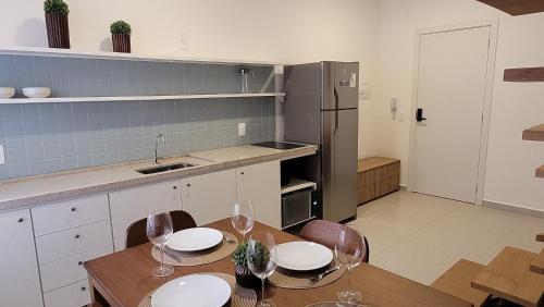 a kitchen with a table and chairs and a refrigerator at Blend Coliving One - 1 in Ribeirão Preto
