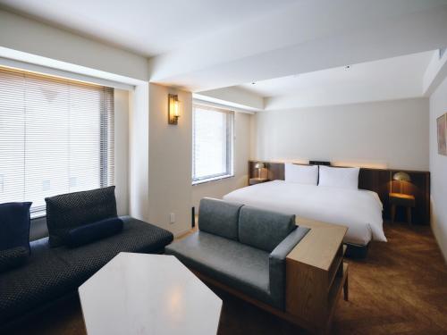 a hotel room with a bed and two chairs at NOHGA HOTEL AKIHABARA TOKYO in Tokyo