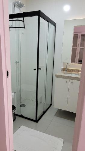 a glass shower in a bathroom with a sink at Blend Coliving One - 1 in Ribeirão Preto