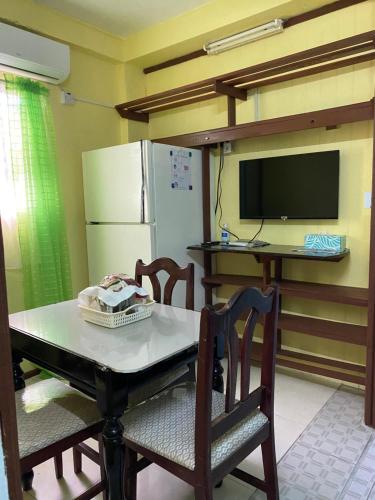 a kitchen with a table with chairs and a refrigerator at Anne's Homestay in Banse