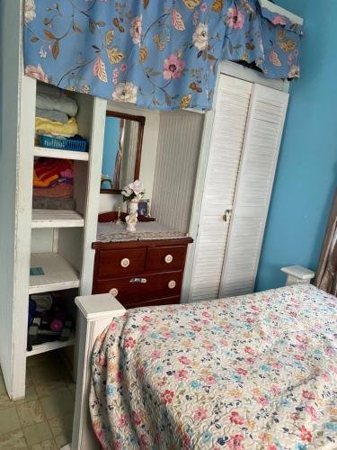 a bedroom with a bed and a dresser and a mirror at Anne's Homestay in Banse