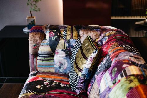 a couch with colorful pillows on it at Hotel Resol Trinity Kanazawa in Kanazawa