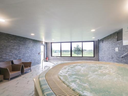 a large hot tub in a room with a couch at Squirrel Cottage in Penrith