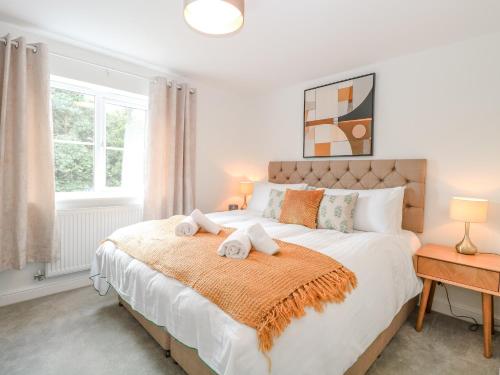a bedroom with a large bed with towels on it at Pine Cottage in Beccles