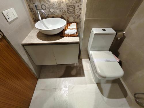 a bathroom with a white toilet and a sink at Hotel Nandini in Dhaka